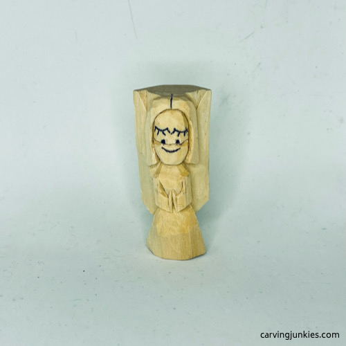 Wood marked for removal on nose of wood carved angel