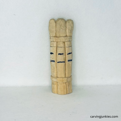 Eye and nose lines drawn on wood carved asparagus