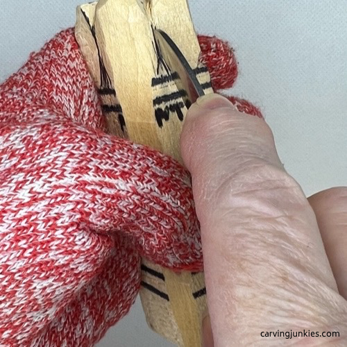 Making a slicing cut on wood carved asparagus