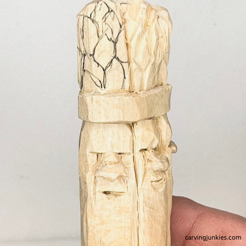 Sketching design on stalk tops of wood carved asparagus