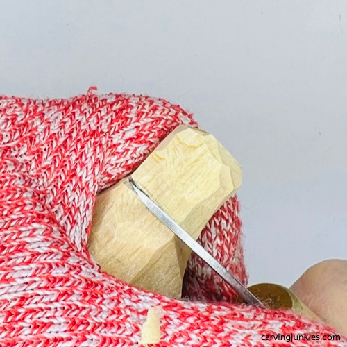 Separating bottom of hat on wood carved Christmas caroloer