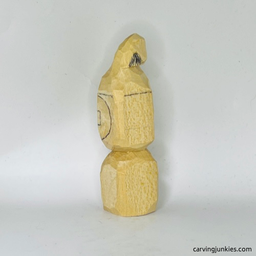 Left view of notch marked for removal on wood carved Christmas caroler