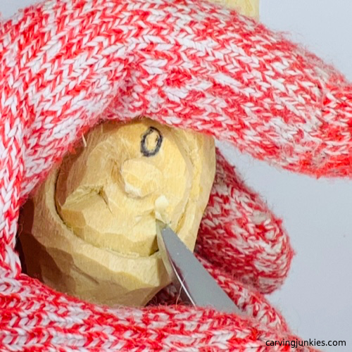 Carving eyes on wood carved Christmas caroler