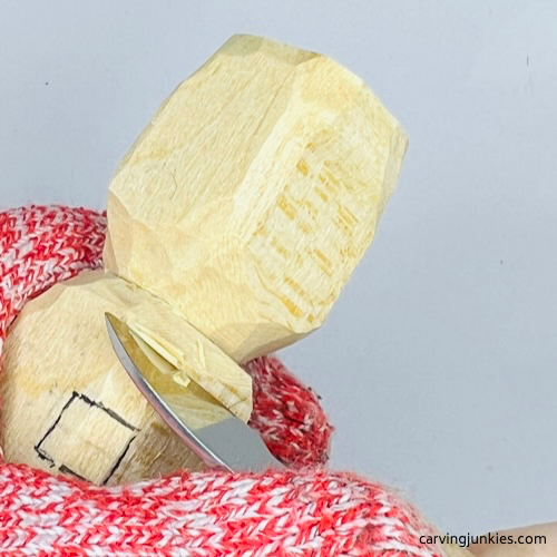 Shaping head on wood carved Christmas caroler