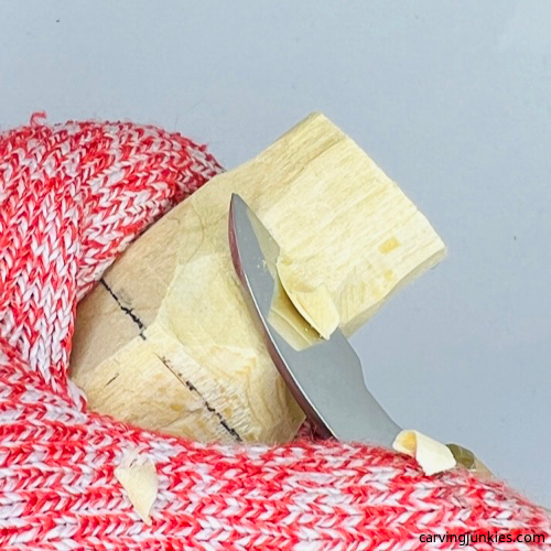 Narrowing hat on wood carved Christmas caroler