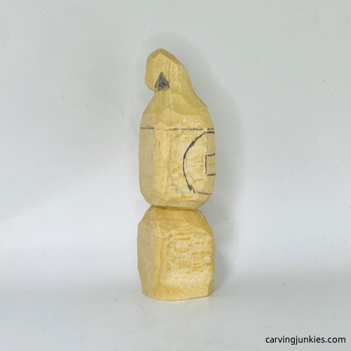 Notch wood marked for removal on wood carved Christmas caroler