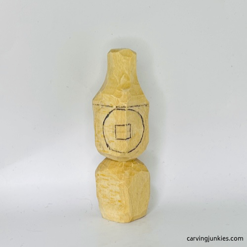 Drawing face guideline on wood carved Christmas caroler