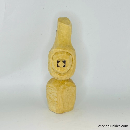 Nose wood marked for removal on wood carved Christmas caroler