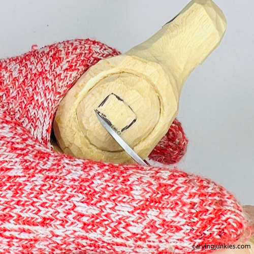 Making stop cut under nose on wood carved Christmas caroler