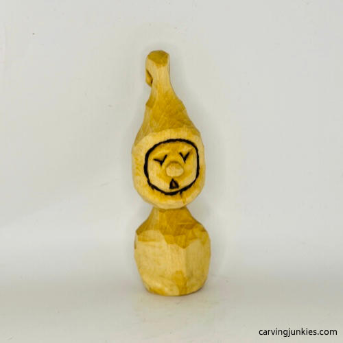 Front view of unpainted  wood carved Christmas caroler