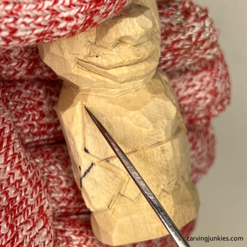Making pyramid cut on arm of wood carved caveman Carving crook of arm on wood carved caveman