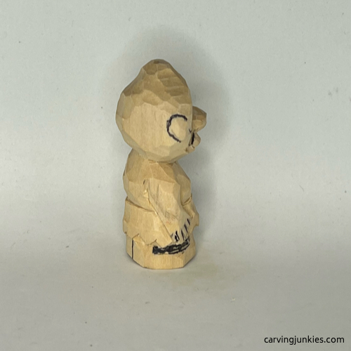 View of details on wood carved caveman right side Right view of details sketched on wood carved caveman
