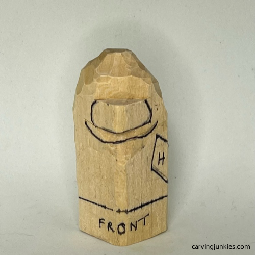 Drawn details on face of wood carved caveman Facial details are added to wood carved caveman