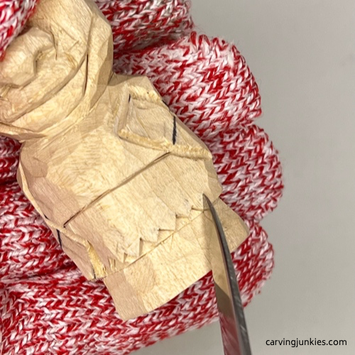 Making small pyramid cuts on wood carved caveman Carving cuts into loincloth of wood carved caveman