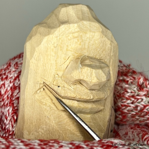 Refining lip on wood carved caveman Narrowing lower lip of wood carved caveman