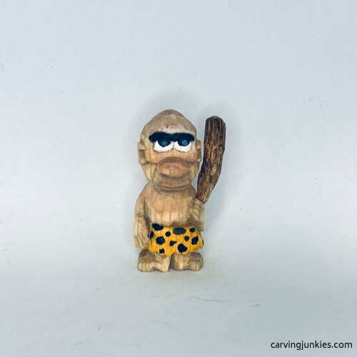 View of painted wood carved caveman from the front Front view of painted wood carved caveman