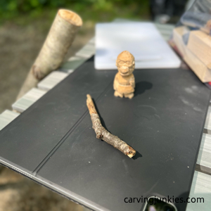 Stick next to wood carved caveman in progress Carving club for caveman wood carving