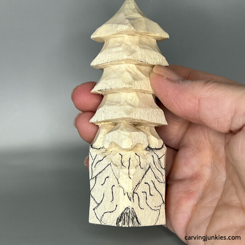 Beard lines are sketched on wood carved Christmas tree gnome