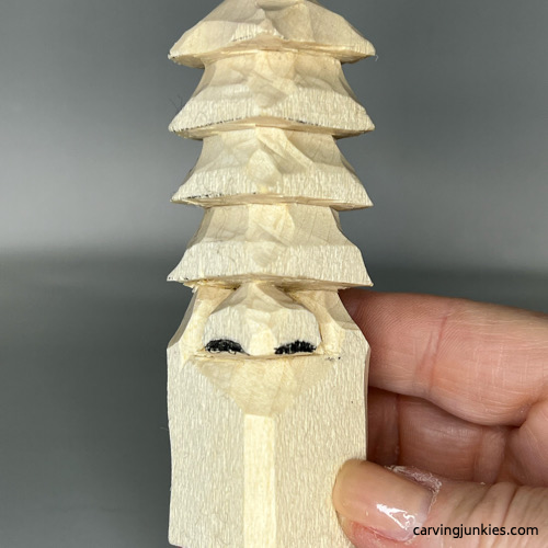 Mark wood for removal on nose of wood carved Christmas tree gnome