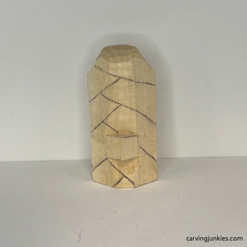 Details are added to wood carved Christmas tree ornament Cross hatch details are drawn on front of wood carved Christmas tree ornament