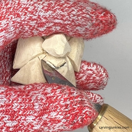 Starting to carve mouth on wood carved Christmas tree ornament Carving the mouth on wood carved Christmas tree ornament