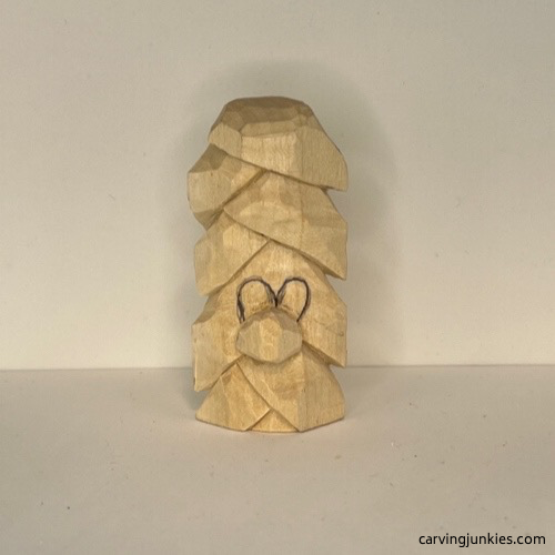 Eyes are sketched on wood carved Christmas tree ornament Eyes are drawn on wood carved Christmas tree ornament