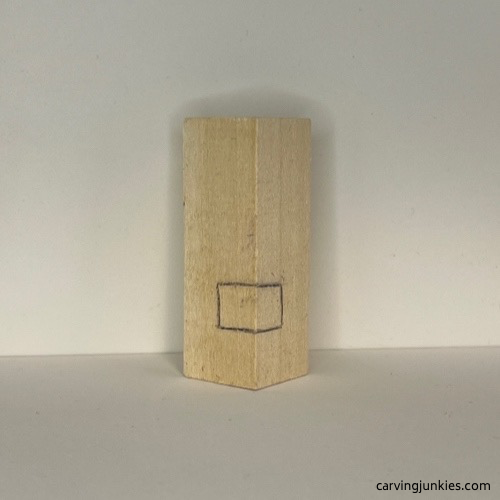 Nose guideline is sketched on wood carved Christmas tree ornament Wood carved Christmas tree ornament nose box is drawn