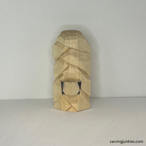 Marked wood to carve on nose of wood carved Christmas tree ornament Marking the nose for removal of wood on wood carved Christmas tree ornament