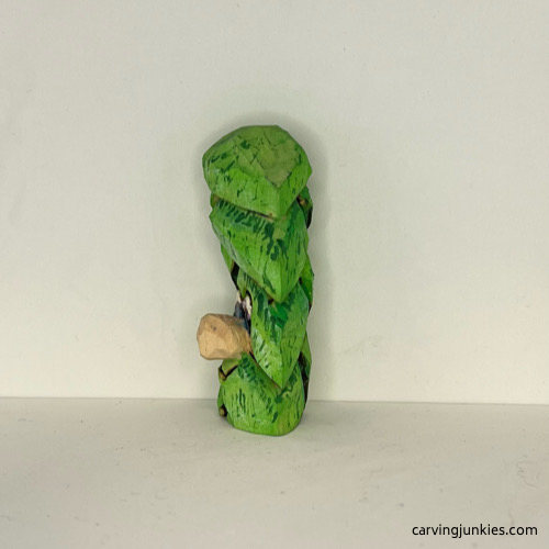 Left view of wood carved Christmas tree ornament after painting Left side of painted ornament