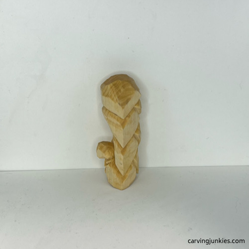 Left side of wood carved Christmas tree ornament before painting Left view of unpainted wood carved Christmas tree ornament