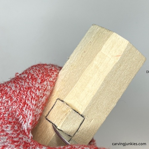 Knife making a stop cut on wood carved Christmas tree ornament Making a stop cut on wood carved Christmas tree ornament