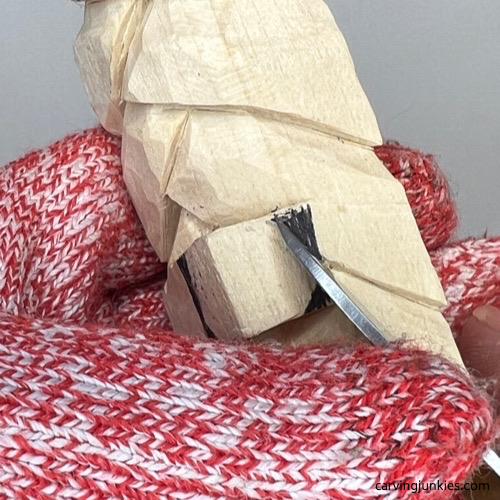 Starting pyramid cut on wood carved Christmas tree ornament Removing wood on the corners of the nose of wood carved Christmas tree ornament