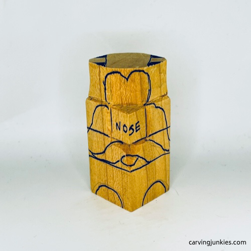 Facial details drawn on wooden carved dog