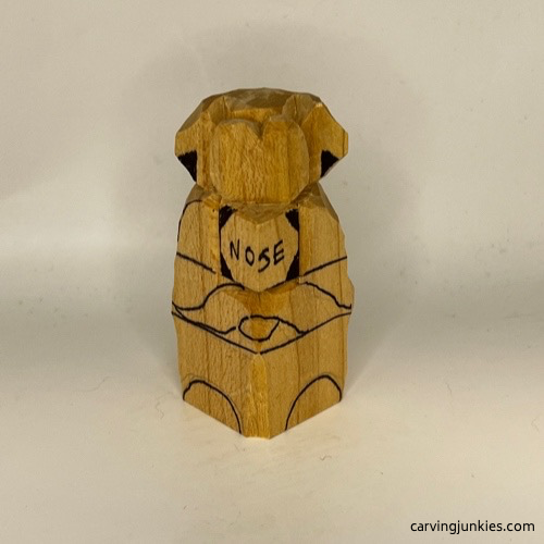 Wood marked on carved dog nose for removal
