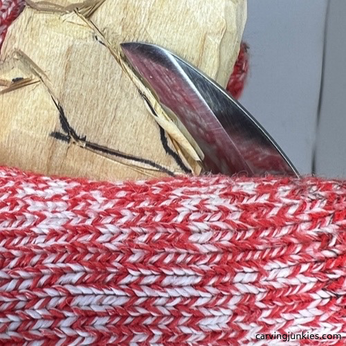 Carving wood with knife on wooden dog carving