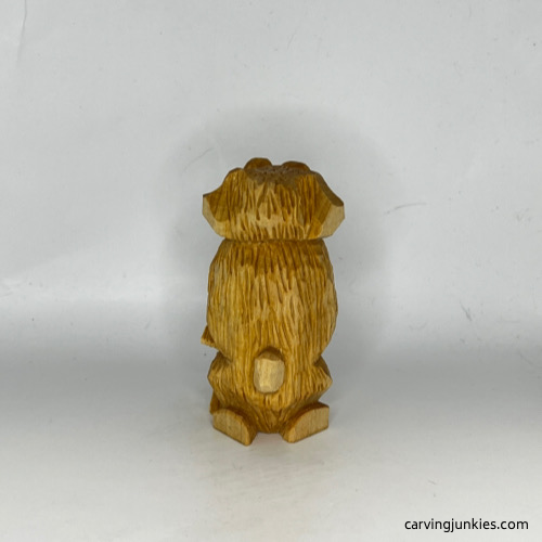 Back view of unpainted carved wooden dog