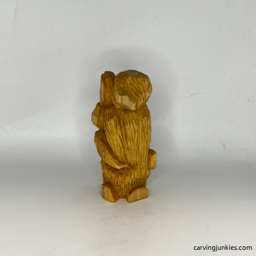 Left view of unpainted carved wooden dog