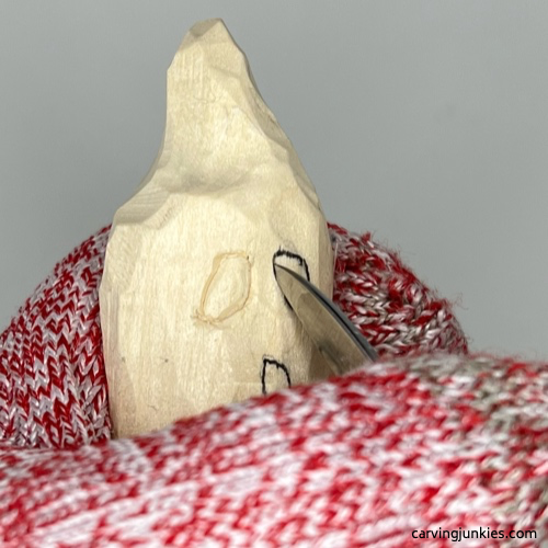 Carving eyes and mouth on wood carved ghost