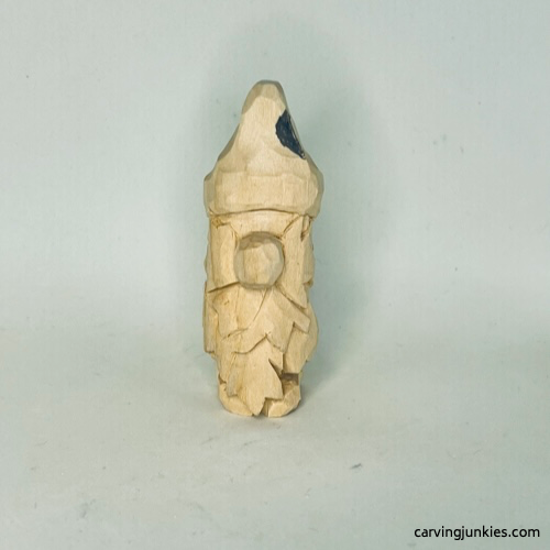 Guideline to shape at on wood carved autumn gnome Wood is marked for removal on hat of fall gnome wood carving