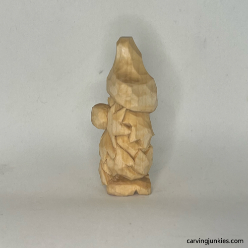 Left side of unpainted wood carved autumn gnome Unpainted left view of fall gnome wood carving