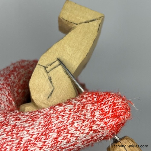 Separating arm on little man caricature carving