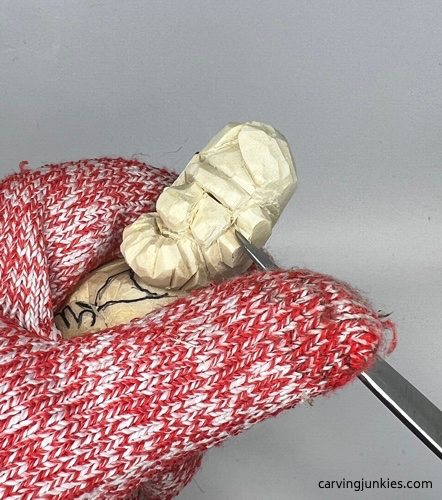 Making a V-cut to separate beard on carved old man