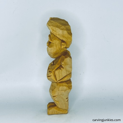 Left side of unpainted tubby man wood carving Left view of unpainted tubby man wood carving