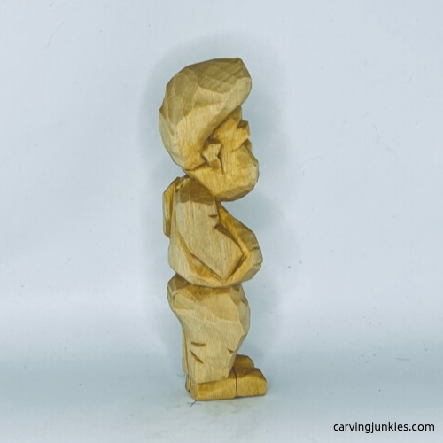 Right side of unpainted tubby man wood carving Right view of unpainted tubby man wood carving