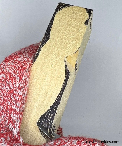 Starting second V cut on tubby man wood carving Making another V cut on tubby man wood carving