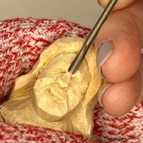 Carving bridge of nose on wood carved mermaid