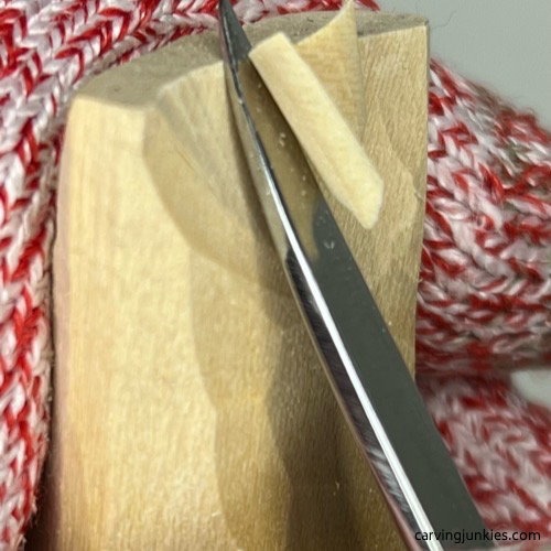 Making a scooping cut on wood carved mermaid