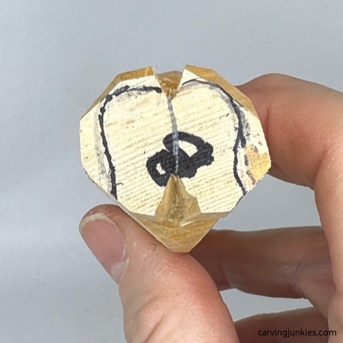 Refining shoe shape on wood carved mummy Shoes are drawn for wooden mummy wood carving