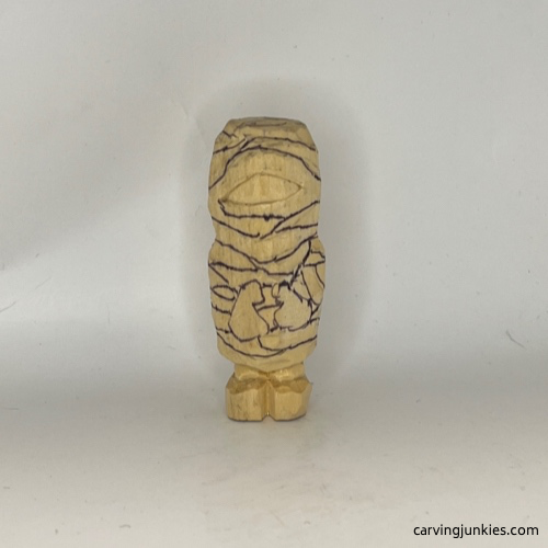 Bandages drawn on front of wood carved mummy Details drawn on front of wood carved mummy