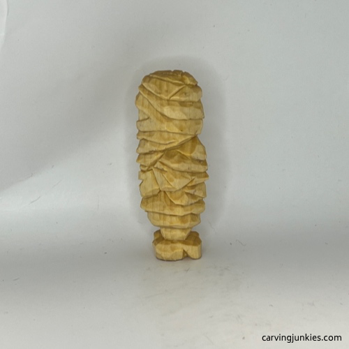 Left side on unpainted wood carved mummy Left view of wood carved mummy before painting